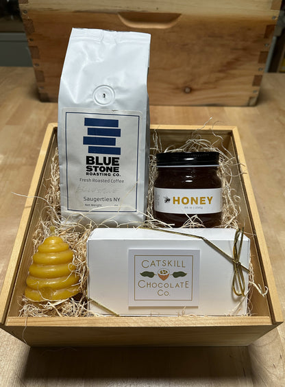 Gift box with Blue Stone Roasting Co. coffee, Catskill Chocolate Co. chocolate, and a jar of honey on a wooden surface.